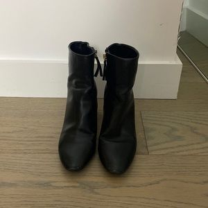 Black leather booties with gold trim in the heel